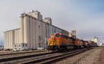 BNSF 7743 leads eastbound stacks past the grain elevators in Hereford, TX